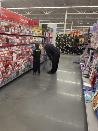 An officer works with a kids to pick out a card during the 2023 Shop with a Cop. Source: Wareham Police Department