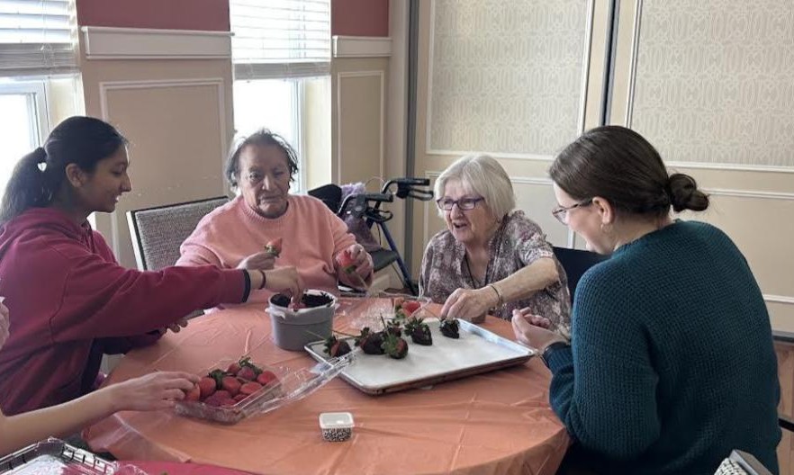 Students work to decorate the strawberries with residents. Photos source: Wareham High School