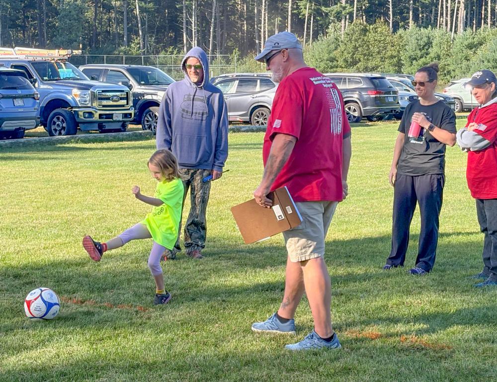 A Youth Soccer player hits a shot while Elks volunteers watch on. Photos by Jim Callan