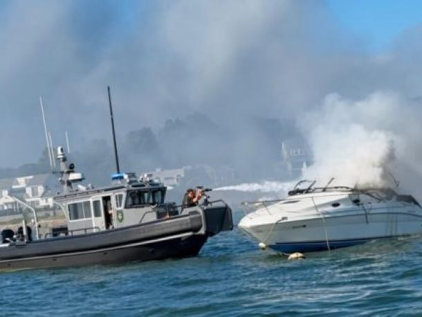 A Wareham Department of Natural Resources vessel douses the burning boat with a water cannon on Saturday, Aug. 8. Photo source: Wareham Department of Natural Resources
