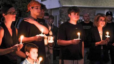 Amy Nadolny's eldest son, Kaiden Machado, second from left, listens to longtime friends of Nadolny share stories and speak on his mother's character and impact she has left on others.
