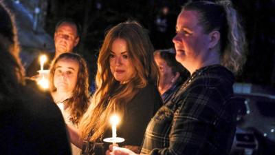 Longtime friends of Nadolny, Kendra Leary, center left, and Shannon Smith, right, look on during the Saturday vigil.