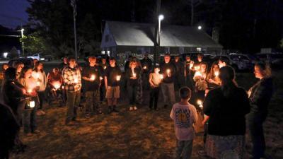 Audience members hold candles as they remembered Nadolny's positive energy and supportive spirit.