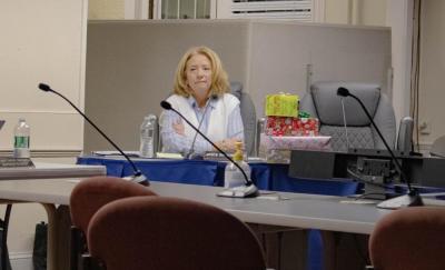 Secretary Joyce Bacchiocchi sits with a pile of gifts.