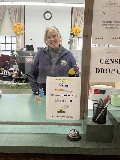  Assistant Town Clerk Shayne Martin and the sign she added pizzaz to with stickers and icons. Photos by Brandy Muz