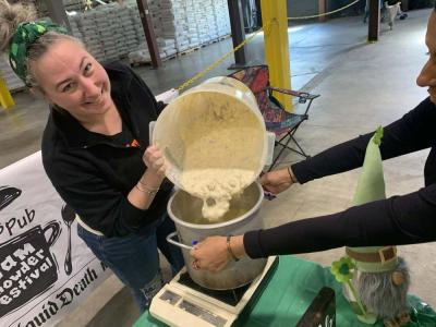 A chef from Pit's Pub pours chowder into the crockpot. 