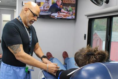 Martinez marks a donor's arm for optimal needle placement. 