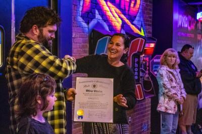 Owner Phill Warren accepts a citation from Kelly Dooner's office. 