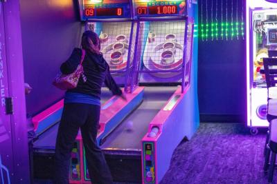 Gamers play skeeball.