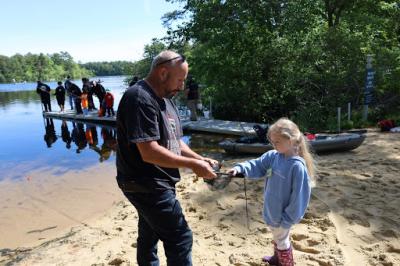 John Krystofolski, left, helps Kyla Stecchi, 5, to hold a fish.