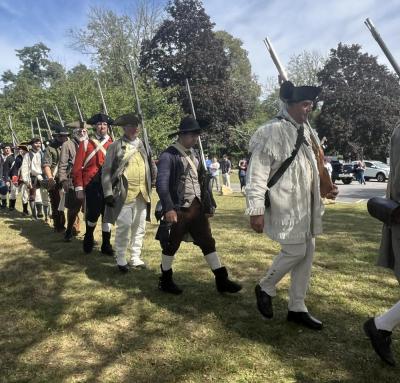 The Minutemen march in traditional clothing during the ceremony.