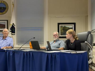 Student representative Emily Brundage, right, tells School Committee Chair Geoffrey Swett, left, and member Roger Bonin, center, about the updated digital hall pass system. Photo by Christian Uva
