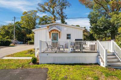 Composite front deck with seating and a grill outside the teal front door of 226 Sanford Road, Westport, MA