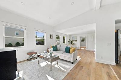 Living room with a vaulted ceiling, large windows and light wood floors at 226 Sanford Road in Westport, MA