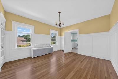 Unit 2 dining room with a chandelier, wainscoting and two windows at 370 Maple Street, New Bedford