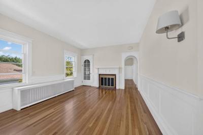 Unit 2 living room with hardwood floors, wainscoting and a fireplace at 370 Maple Street, New Bedford