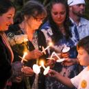Amy Nadolny's son, Joshua Veary, 7, passes a flame between candles of family members and longtime friends during the vigil for Nadolny, Saturday, Oct. 4. Photos by Sam Tucker