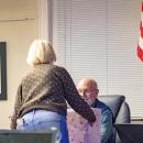 Nancy Tynan Cederholm hands  Kevin Brogioli a present.