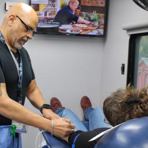 Martinez marks a donor's arm for optimal needle placement. 