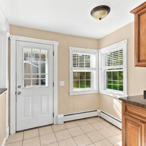 Kitchen with granite counters, a back door and two windows in the apartment at 17 Beeden Road, Westport, MA