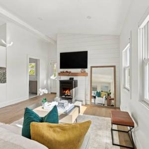 Open living room with a lit pellet stove, looking toward the renovated kitchen at 226 Sanford Road, Westport