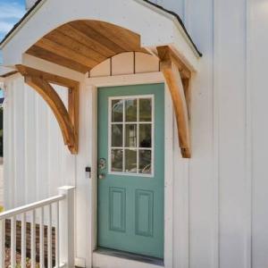 Teal entry door under a curved cedar front portico at 226 Sanford Road, Westport, MA